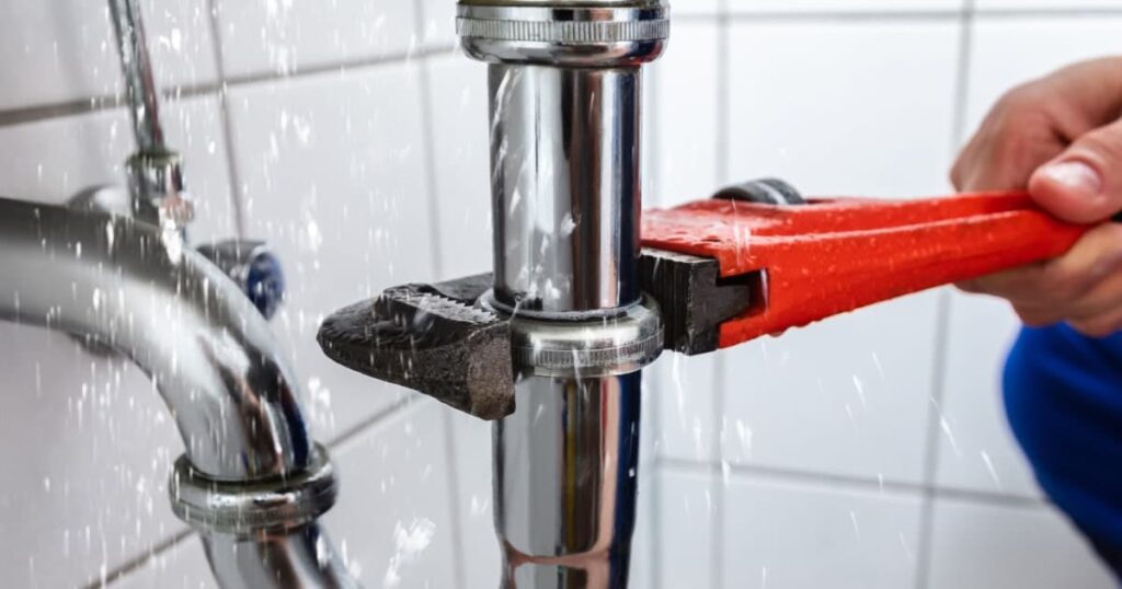 Un plombier réparant une fuite importante sous un robinet
