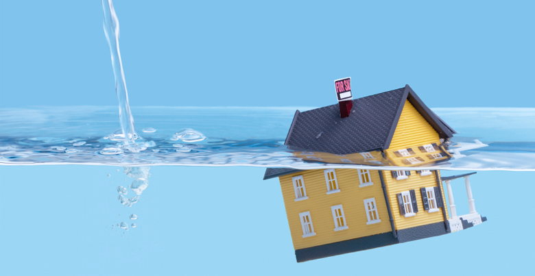 Une maquette de maison plongée dans un bac d'eau qui se remplit. 
